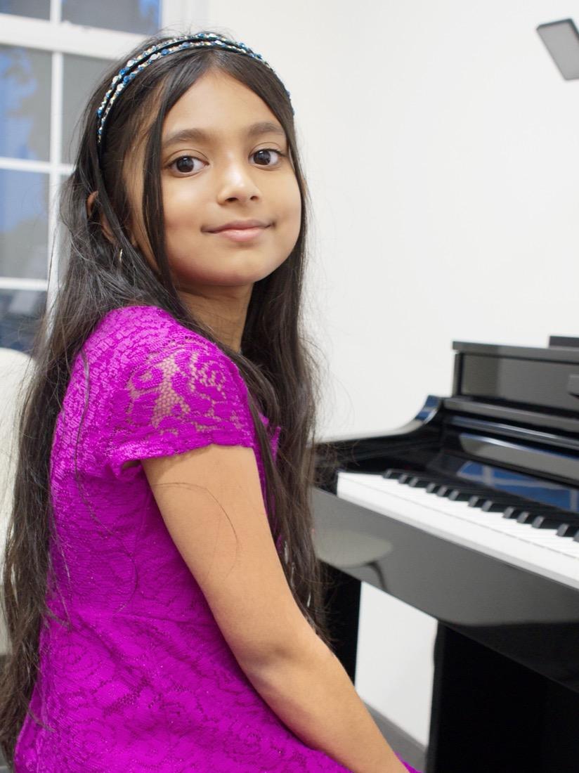 A young pianist in recital dress at the grand piano